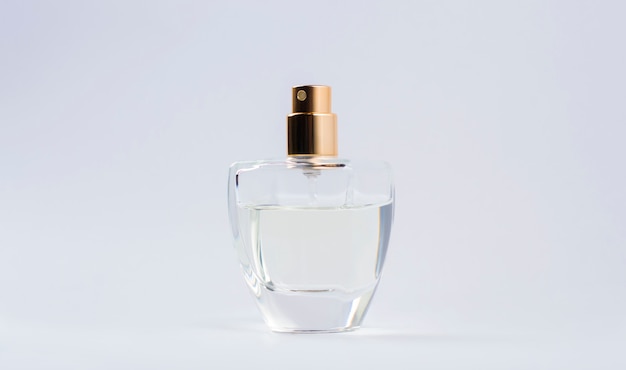 Flacon de parfum transparent sur fond gris