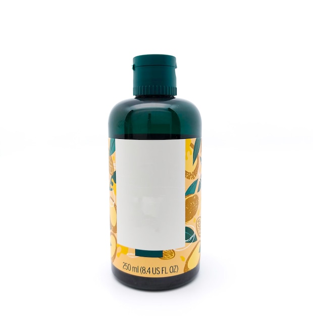Photo flacon en plastique vert foncé de 250 ml avec motif nature isolé sur blanc flacon de produit essentiel pour le bain