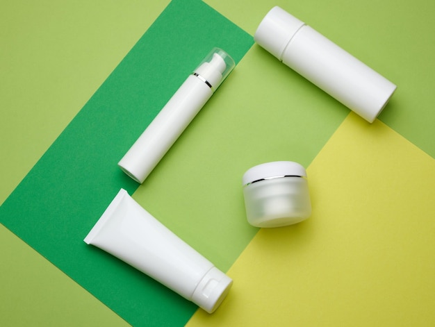 Flacon de pot et tubes en plastique blanc vides pour cosmétiques sur fond vert Emballage pour la publicité de sérum de gel crème et la promotion de produits maquette