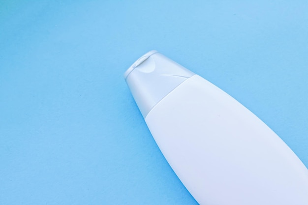Flacon de récipient cosmétique à étiquette vierge comme maquette de produit sur fond bleu