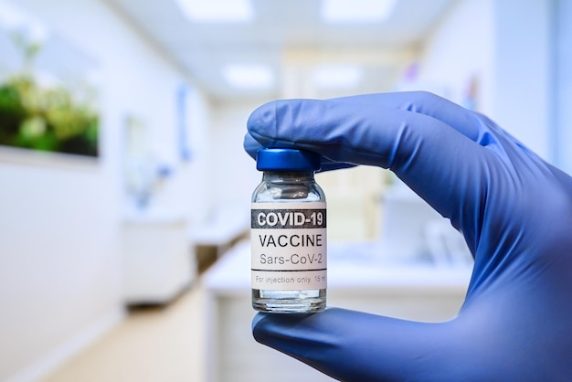 Flacon de vaccin COVID19 dans la main du médecin à la clinique