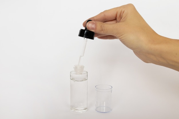 Flacon en verre compte-gouttes. Pipette cosmétique sur blanc.