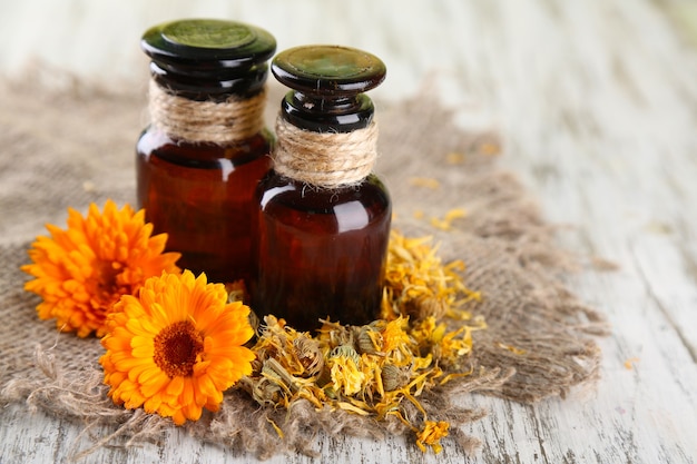 Flacons de médicaments et fleurs de calendula sur bois