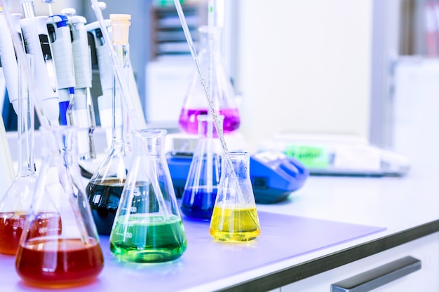Flacons avec des réactifs liquides colorés dans un laboratoire scientifique. Bleu tonique