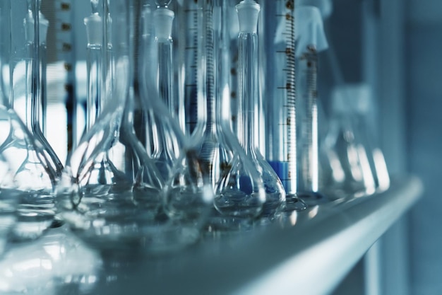 Flacons en verre de laboratoire et tubes à essai sur un support.