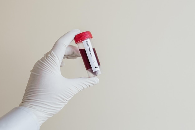 Photo flacons en verre transparent avec étiquettes et avec une seringue de vaccin test covid19 sur un bureau