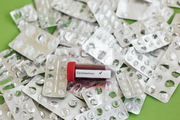 Photo flacons en verre transparent avec étiquettes et avec une seringue de vaccin test covid19 sur un bureau