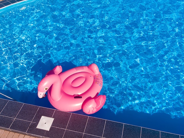 Flamant rose gonflable dans l'eau de la piscine