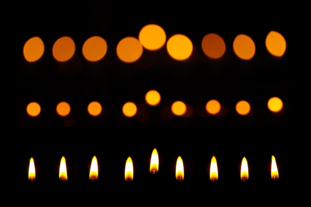 La flamme de la bougie est isolée dans le fond noir des bougies de Hanoukka
