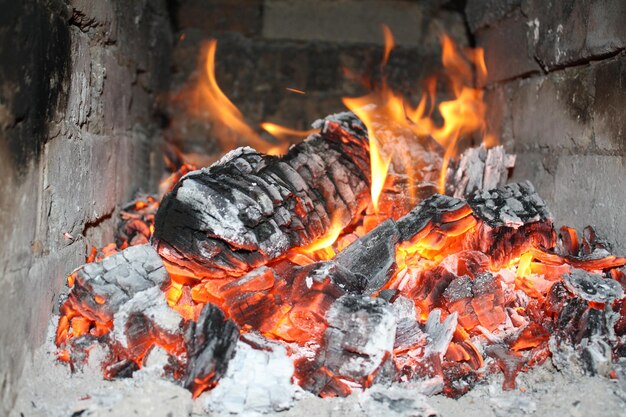 Photo une flamme brillante brûlant du bois de chêne dans un four en pierre rustique en gros plan