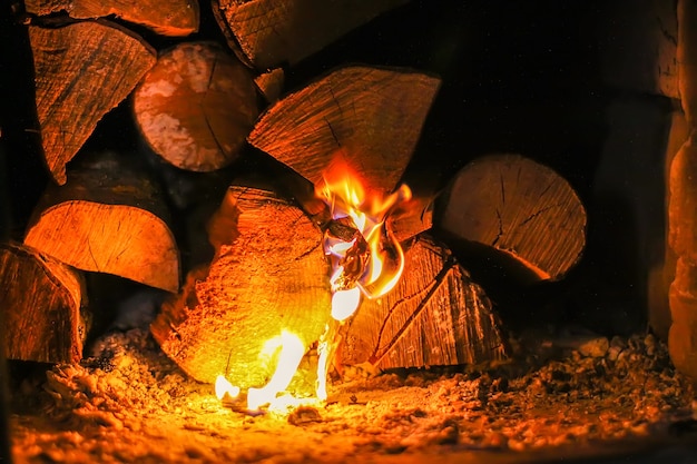 Flamme chaude et bois de chauffage dans le vieux poêle du village.