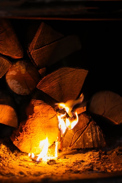 Flamme chaude et bois de chauffage dans le vieux poêle du village.