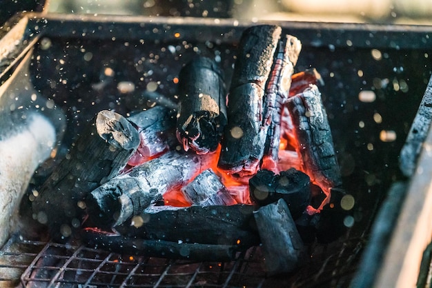 Flamme et étincelle de feu avec bokeh provenant de la combustion de charbon de bois sur un gril