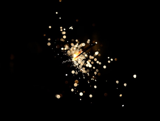 Flamme de feu d'artifice de cierge magique de Noël sur le noir