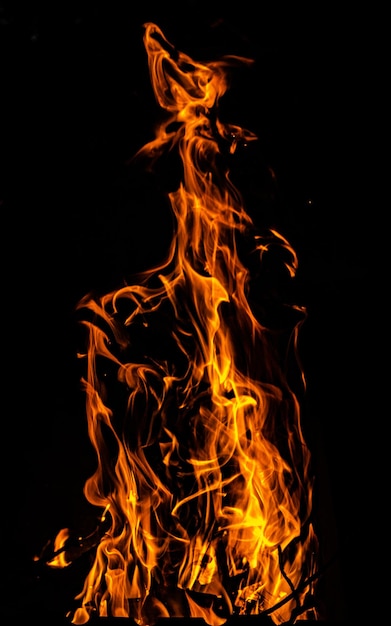 Photo flamme de feu de joie sur fond sombre arrière-plan abstrait sur le thème de la chaleur légère et de la vie