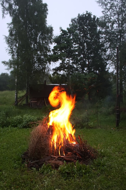 Flamme lumineuse de feu de joie sur le terrain rural le soir