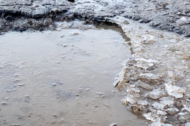 Flaque d'eau gelée sur la route en gros plan