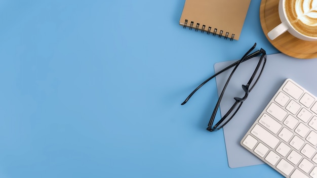 Flat lay, espace de travail de bureau vue de dessus avec carnet de notes vierge, clavier