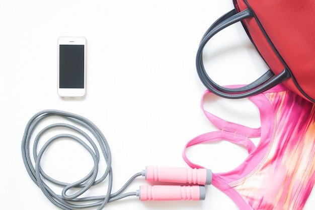 Flat lay of sport and fitness equipment with smartphone isolated on white background