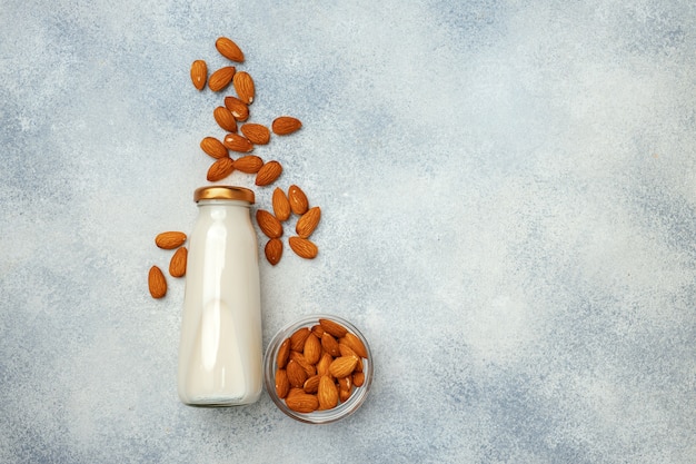 Flatlay avec bouteille en verre de lait de noix et de noix sur un bureau en bois