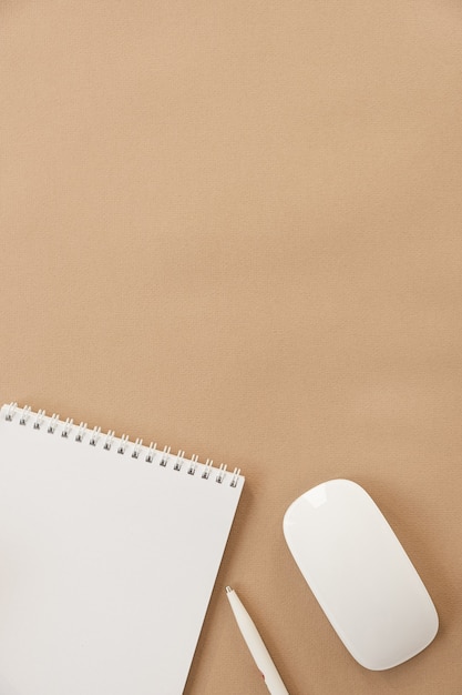 Flatlay de cahier de feuille vierge sur fond pastel beige. Espace de travail minimaliste pour le bureau à domicile. Mise à plat, vue de dessus