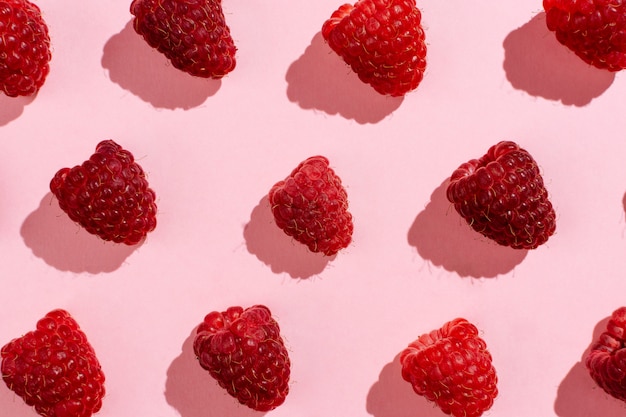 Flatlay de framboises disposées sur rose