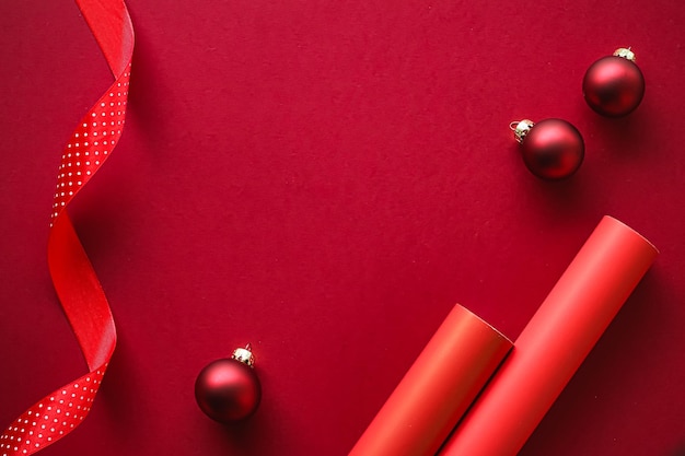 Flatlay de Noël et vacances design concept décoration ornement et emballage cadeau de Noël sur papier rouge...
