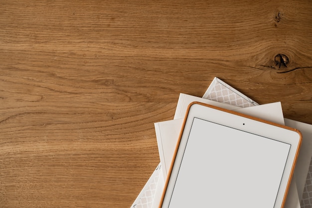 Flatlay de tablette à écran vierge, feuilles de papier sur bois