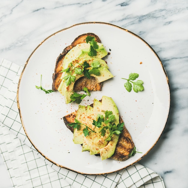 Flatlay de toasts à l'avocat sur fond de marbre culture carrée