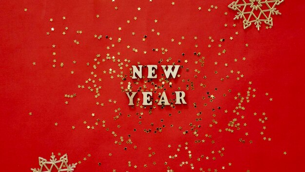 Photo flatley de noël avec des lettres de la nouvelle année sur fond d'or rouge bijoux décoration gros plan brillant