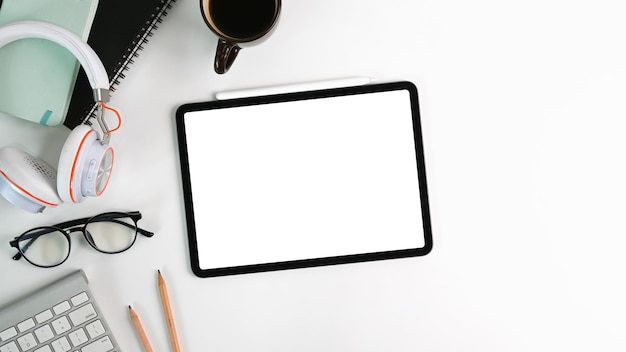 Flay lay vue de dessus bureau blanc avec talet numérique avec casque à écran vide lunettes tasse à café et ordinateur portable