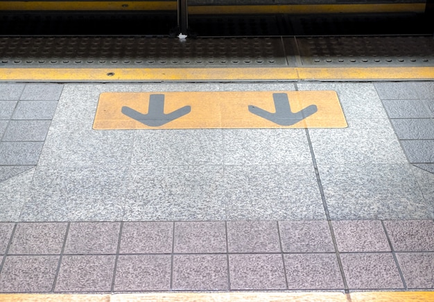 Flèche signe dans le plancher à la gare, signe de transport