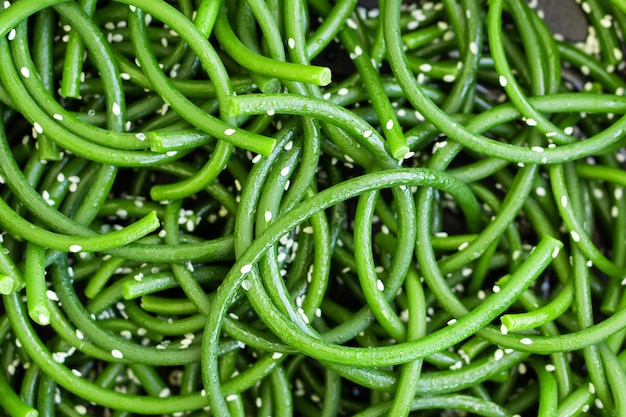 Flèches d'ail vert frais avec graines de sésame gros plan Cusine asiatique Ingrédients pour la nourriture Vue de dessus