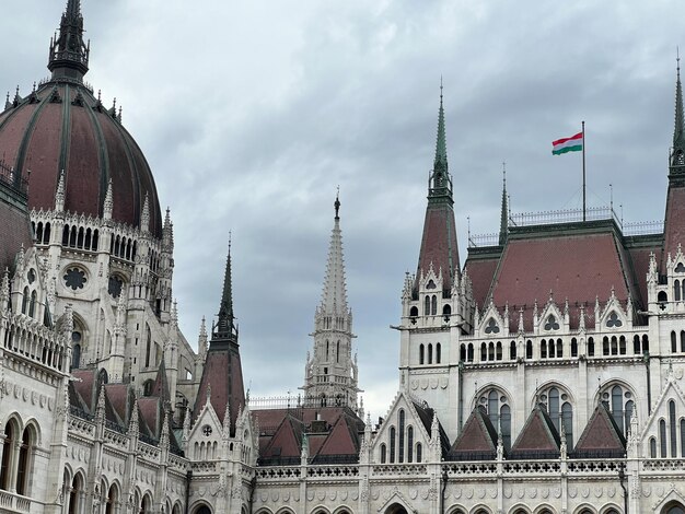 Photo les flèches du parlement hongrois avec un drapeau flottant à budapest