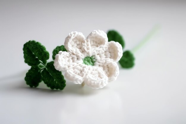 Une fleur au crochet avec une feuille verte dessus