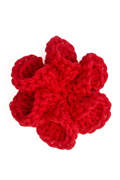 Fleur colorée tricotée au crochet comme pinces à cheveux sur fond blanc isolé