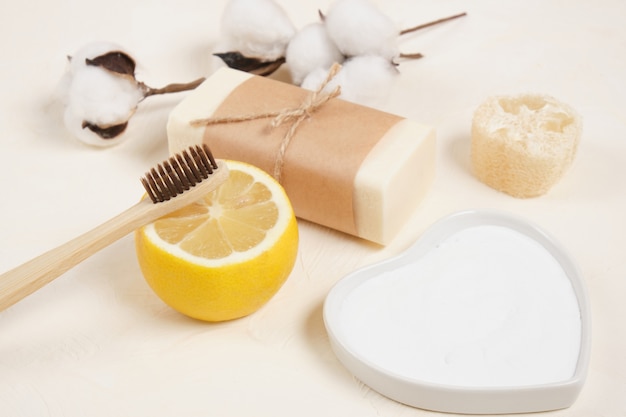 Fleur de coton, citron, luffa, savon et bicarbonate de soude pour le ménage. concept de mode de vie écologique, zéro déchet, vue de dessus de l'espace de copie de nettoyage écologique