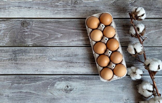 Fleur de coton et oeufs de Pâques sur fond de bois