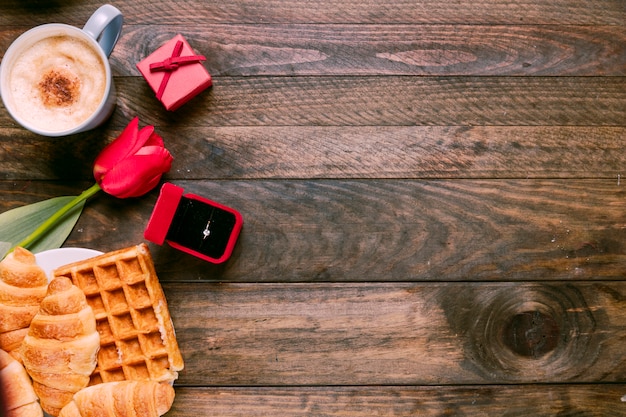 Fleur fraîche, boulangerie, bague dans une boîte cadeau et tasse de boisson