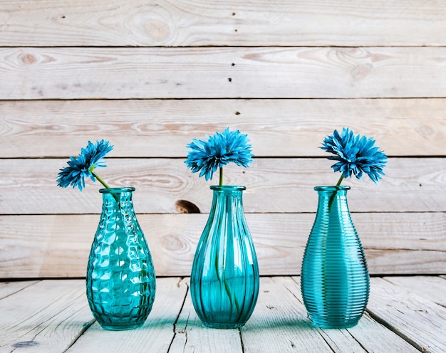 Photo fleur de gerbera bleu dans un vase sur fond de bois