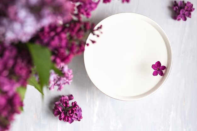 Fleur lilas à cinq branches parmi les fleurs lilas dans une tasse avec de l'eau. Faire de l'espace pour le texte. Branche de lilas avec une fleur à 5 pétales.