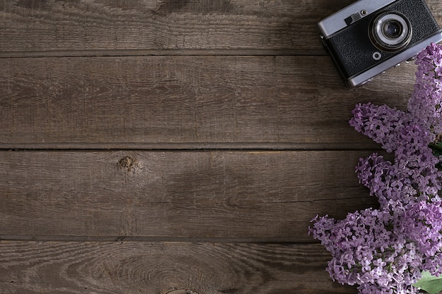 Fleur de lilas sur fond en bois rustique avec un espace vide pour le message d'accueil. Concept de fond de printemps. Vue de dessus