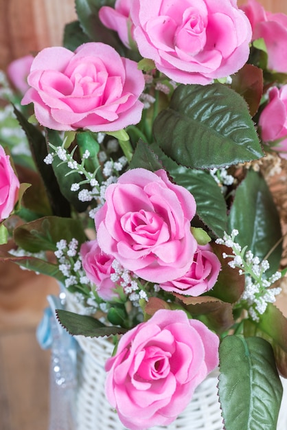 fleur rose dans vase pot, dans la table de café avec fond en bois