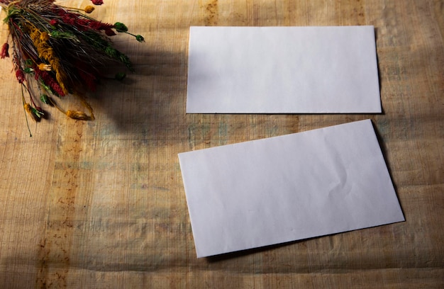 Fleur sèche avec carnet vierge sur une vieille table en bois ton vintage