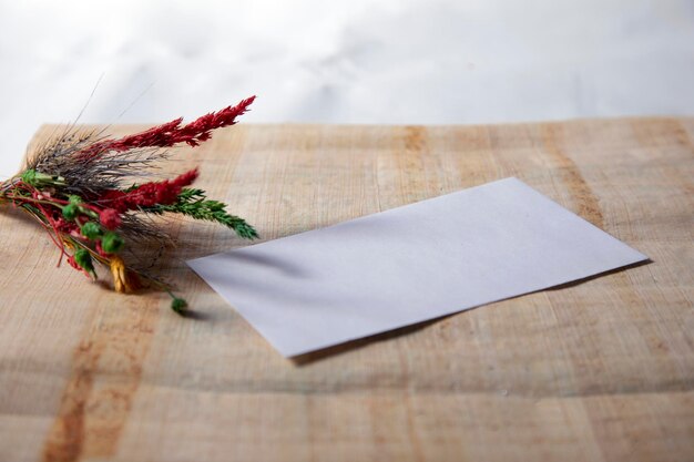 Fleur sèche avec carnet vierge sur une vieille table en bois ton vintage