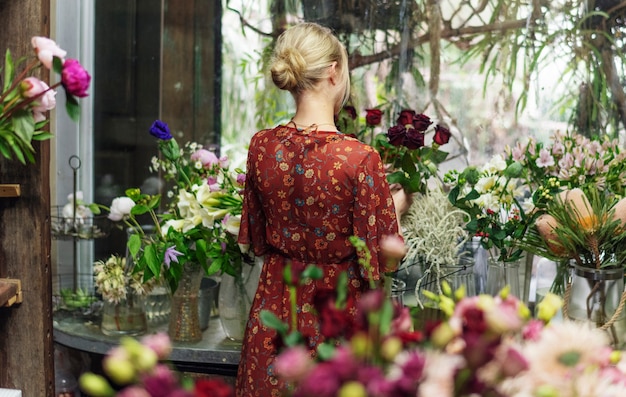 Fleuriste arrangeant des roses dans sa boutique