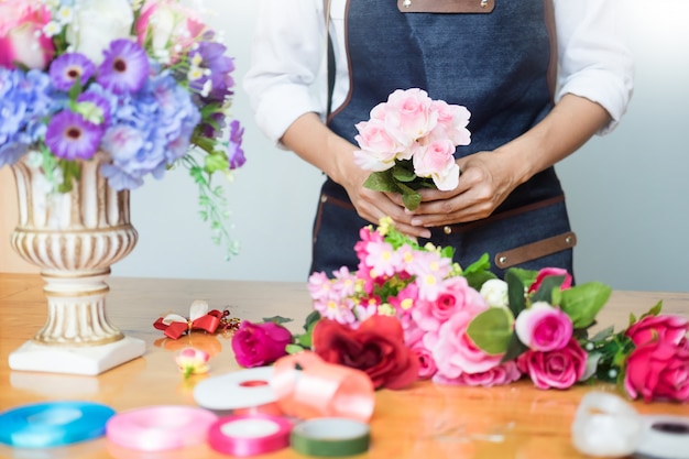 Fleuriste Arranger beau gilet artificiel au magasin de fleurs