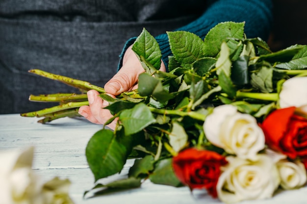 Le fleuriste au travail fait un bouquet moderne à la mode de différentes fleurs