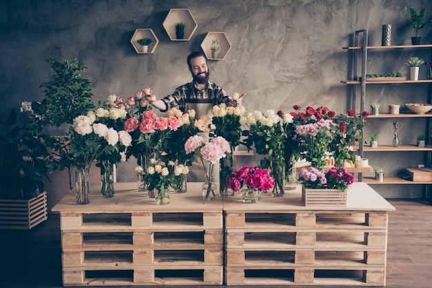 fleuriste barbu travaillant dans son magasin de fleurs