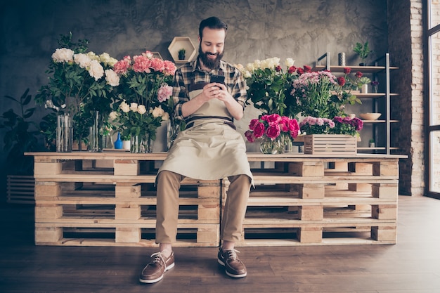 fleuriste barbu travaillant dans son magasin de fleurs